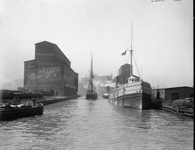 Photograph of the river with a grain elevator, a steamer and a schooner